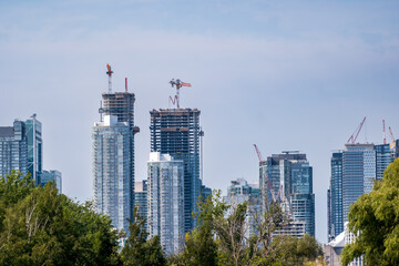 construction cranes and cement pumps working to build multiple skyscrapers on a  big city (toronto)...