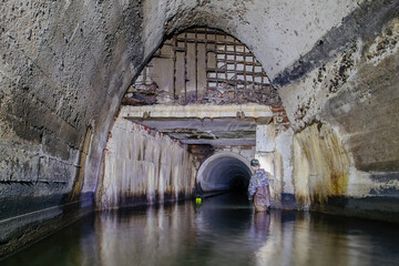 Man explores sewer tunnel or underground river
