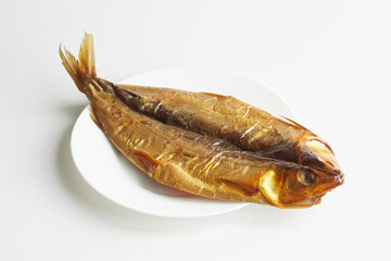 Prepared gutted smoked Baikal omul in a white plate on a white background. Rare fish delicacy - omul. Photo. Selective focus. Copy space.