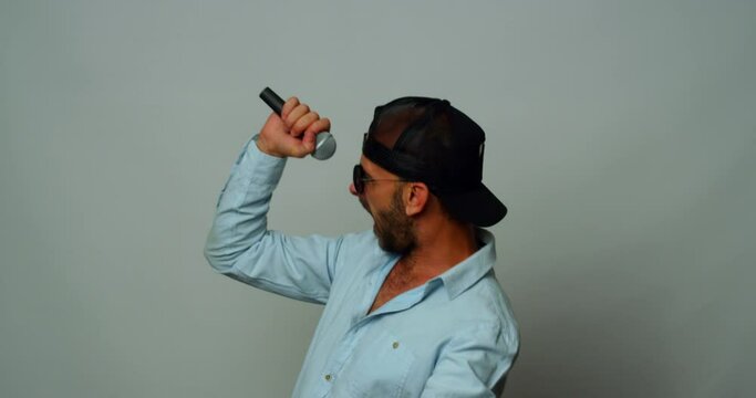 A middle-aged man dances and sings wildly in the studio