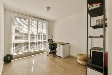 a home office with wood flooring and white shutters on the windows overlooking out onto an outside patio area