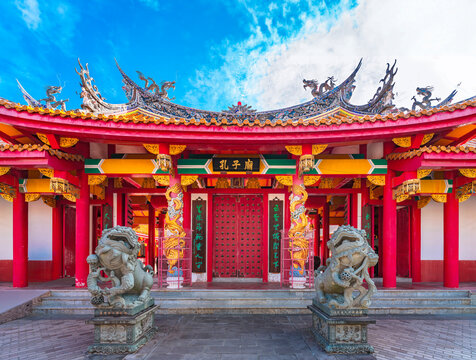 nagasaki, kyushu - dec 13 2022: Red gate of the Japanese Confucius Shrine called Kōshi-byō adorned with golden dragons and fenghuang phoenix on it and protected by two chinese shishiko guardian lions.