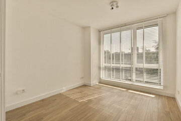 an empty room with wooden floors and white shutters on the windows, looking out onto the cityscapea