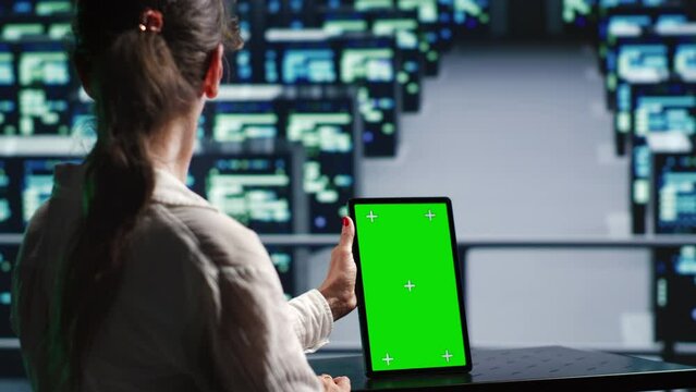Skillful employee in server hub housing high end units capable of quickly and efficiently performing complex computations and data analysis, using mockup tablet to prevent perils