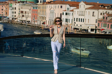 Fototapeta na wymiar Fashion woman portrait of young pretty trendy girl posing at the Venice in Europe. Summer Venice, fashion street. Woman enjoying vacation in Venice during summer. Luxury travel in Venice, Italy.