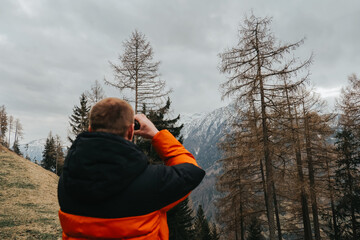 Man with binoculars in the mountains.Viewing the mountains with binoculars.Equipment and gear for hiking in the mountains.Sports and walking in the mountains