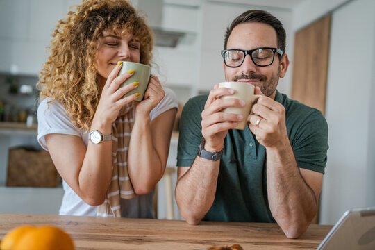 Young couple man and woman enjoy cup of tea or coffee in the morning