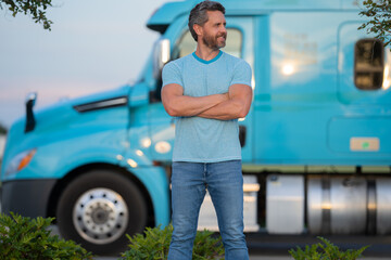 Men driver near lorry truck. Man owner truck driver in t-shirt near truck. Handsome middle aged man...