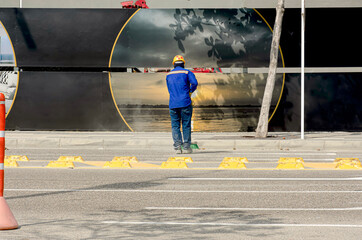 Young worker of a company performs cleaning at the entrance of the building.