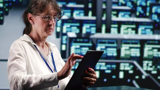 Meticulous mechanic in cloud computing business housing high end servers capable of quickly and efficiently performing complex computations and data analysis, using tablet to cancel disruptions