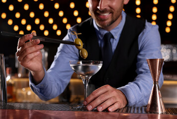 Bartender preparing fresh alcoholic cocktail in bar, closeup