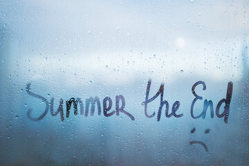 Handwritten lettering Summer the End and sad smile on window