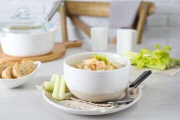 Bowl of delicious celery soup served on white table
