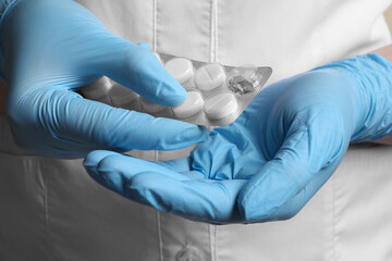 Doctor taking pill out from blister pack, closeup