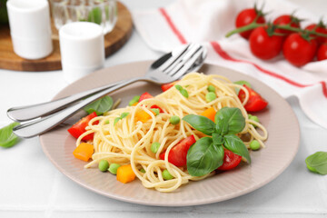Plate of delicious pasta primavera served on white table, closeup