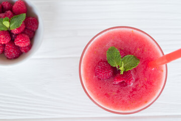 Raspberry smoothie red colorful fruit juice milkshake blend beverage healthy high protein the taste yummy In glass drink episode morning on white wood background from top view.