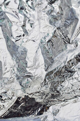 Closeup of aluminum foil revealing its reflective surface and silvery texture, ideal for elegant projects.