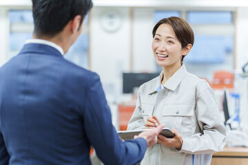 事務所で打ち合わせをするビジネスマンと女性作業員