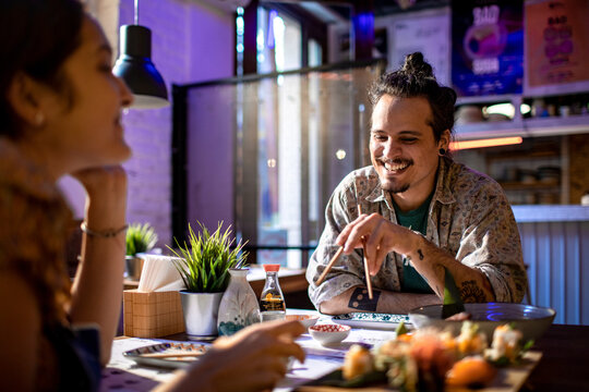 Young caucasian couple having a date in a japanese style sushi restaurant bar