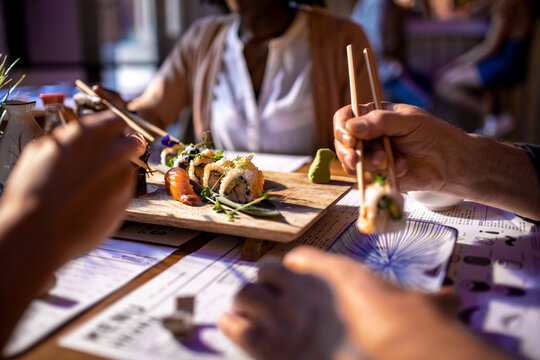 Diverse and mixed group of people having a meeting at a japanese styled sushi restaurant