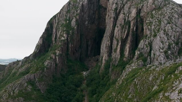 Drone flight toward dark hole through Torghatten mountain in twilight