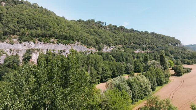 Drone shot over forest with smoke from a steam train in the woods, aerial view in summer, Lot, France