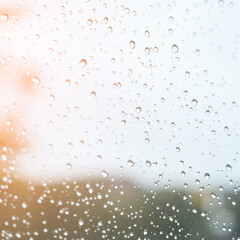 blur background with sunlight on rainy day, water droplet on mirror