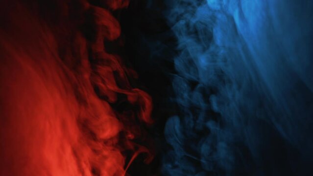 Color mist. Cold flame. Esoteric aura. Blue red glowing smoke cloud motion on dark black copy space abstract background.