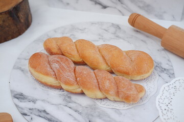 Freshly baked croissants on a marble board with wooden rolling pin