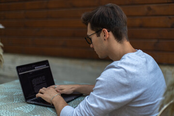 A student is working at a laptop in the park.