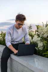 A student is working at a laptop in the park.