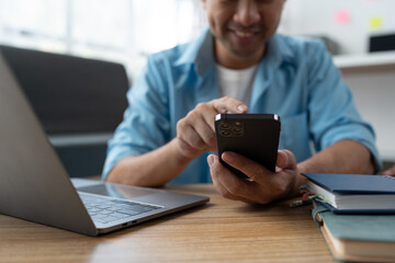 Young Asian businessman using mobile phone, laptop to communicate find financial information Digital banking, internet payment, online shopping via mobile app, financial technology, ecommerce concept