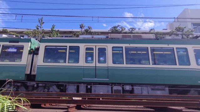 高校の校舎の前を走るレトロな電車。

