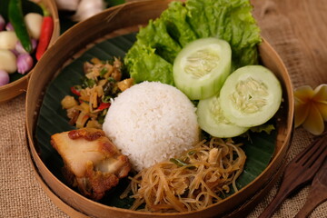 Nasi Berkat Wonogiri. is rice with side dishes of fried chicken, stir-fried noodles with soy sauce, stir-fried spicy vegetables, fresh vegetables. nasi kenduri. ayam goreng, bakmi, lalapan.  besek. 