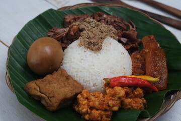 Nasi Gudeg Krecek  is rice and gudeg, which is made from processed young jackfruit, coconut milk, spices, tofu, eggs and chicken. Yogyakarta specialties. Indonesian food. Served with banana leaves. 