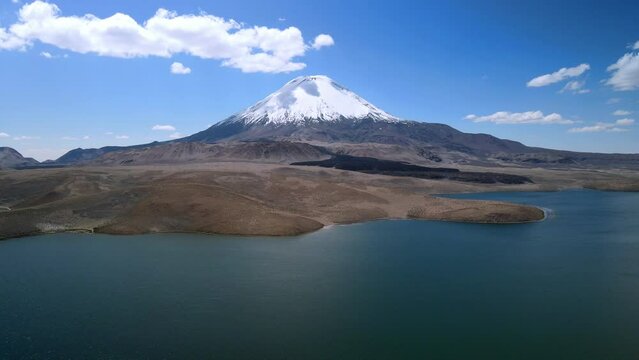 Aerial view over of the scenic Chungara Lake and Parinacota volcano, Chile - reverse, drone shot