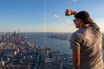 A man in sunglasses enjoying the view of New York City skyline over the Hudson River during the...