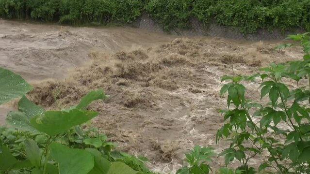 大雨の後に濁流が流れる川
