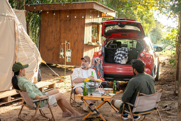 Group tourists drinking beer-alcohol and play guitar together with enjoy and happiness in Summer while camping