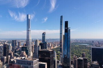 Vibrant urban skyline with towering skyscrapers and impressive architecture seen from Top of The Rock in New York. View on the Central Park from above. Hudson river on the side. Modern and lively city