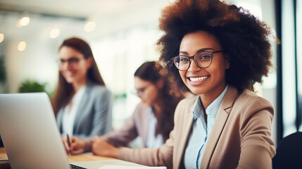 Group of students working together with laptops in a classroom