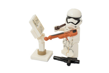 Naklejka premium Lego minifigure of stormtrooper Star Wars is playing a violin as stop war concept. Editorial illustrative image of popular plastic toy constructor.