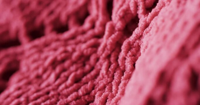 Micro video of close up of pink wooly crochet fabric with copy space