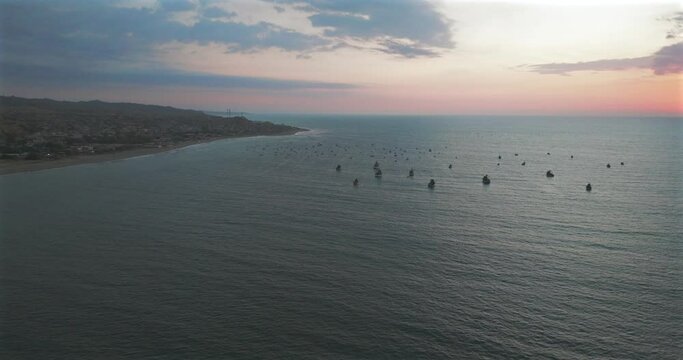 Aerial view of beautiful sunset behind in the ocean fishing boats.