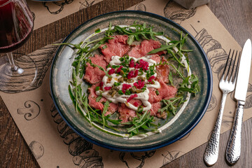 marble beef carpaccio with herbs and sauce