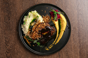 steak with sauce on a black plate