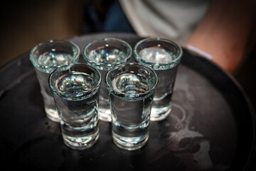 glasses of vodka on a tray 