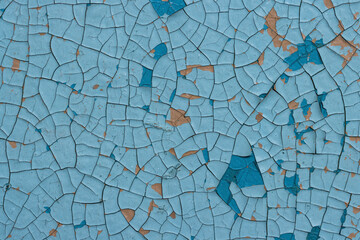 Blue peeling paint on the wall. Old concrete wall with cracked flaking paint. Weathered rough painted surface with patterns of cracks and peeling. High resolution texture for background and design.