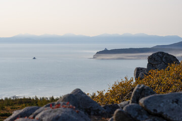 View of the rocks and the sea coast. Sea bay and cape. Autumn season. Blurred foreground.