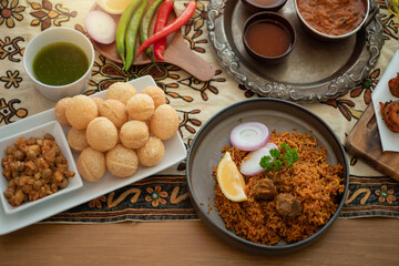 Biryani and Pani puri are both popular Indian dishes, ready to eat on the table, top view, natural wooden background